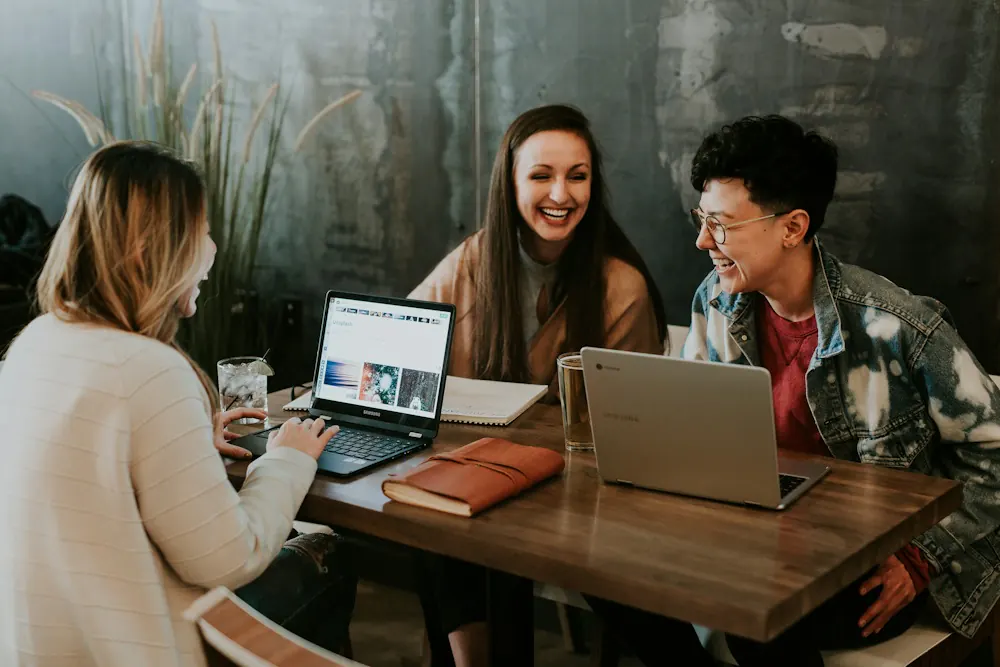 Small startup team laughing while reviewing results together