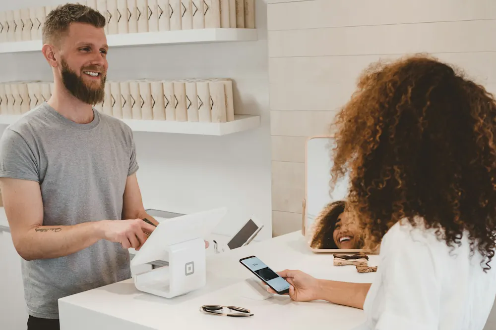 Customer paying at a shop counter while the owner chats